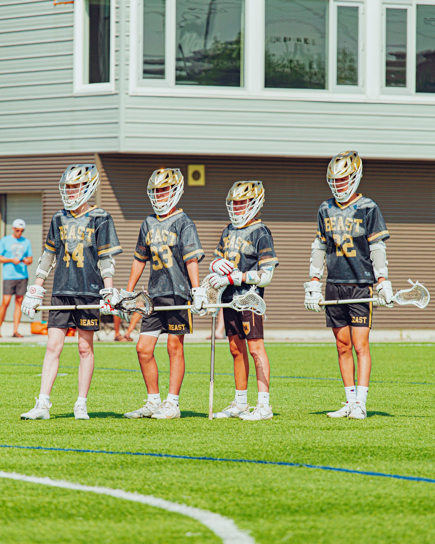 Four BEAST players lined up in gold helmets