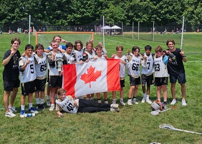 BEAST players and coaches holding a Canadian flag on a U.S. tournament field