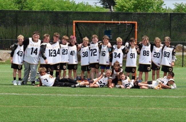 A BEAST team lined up arm in arm in front of a lacrosse goal